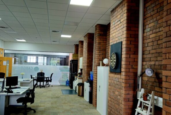 Spacious office rental in Oldham at RamUnique office space in Oldham at Ram Mill Business Centre, featuring exposed brick pillars, a built-in dartboard for breaks, and a bright, open-plan layout for productive work