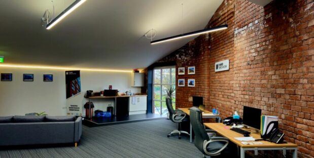 Characterful office space in Oldham at Ram Mill Business Centre, featuring exposed brick walls, natural light, cosy seating areas, and a kitchenette for a comfortable work environment