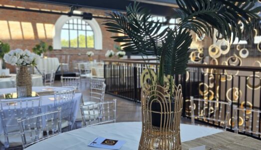 Stunning event setup at Heritage 1907, Ram Mill in Oldham, with gold and black decor, elegant table settings, and a festive atmosphere